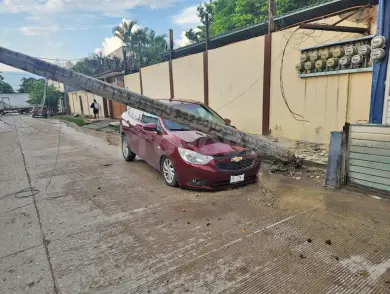 Tráiler derriba poste y cae en vehículo aparcado